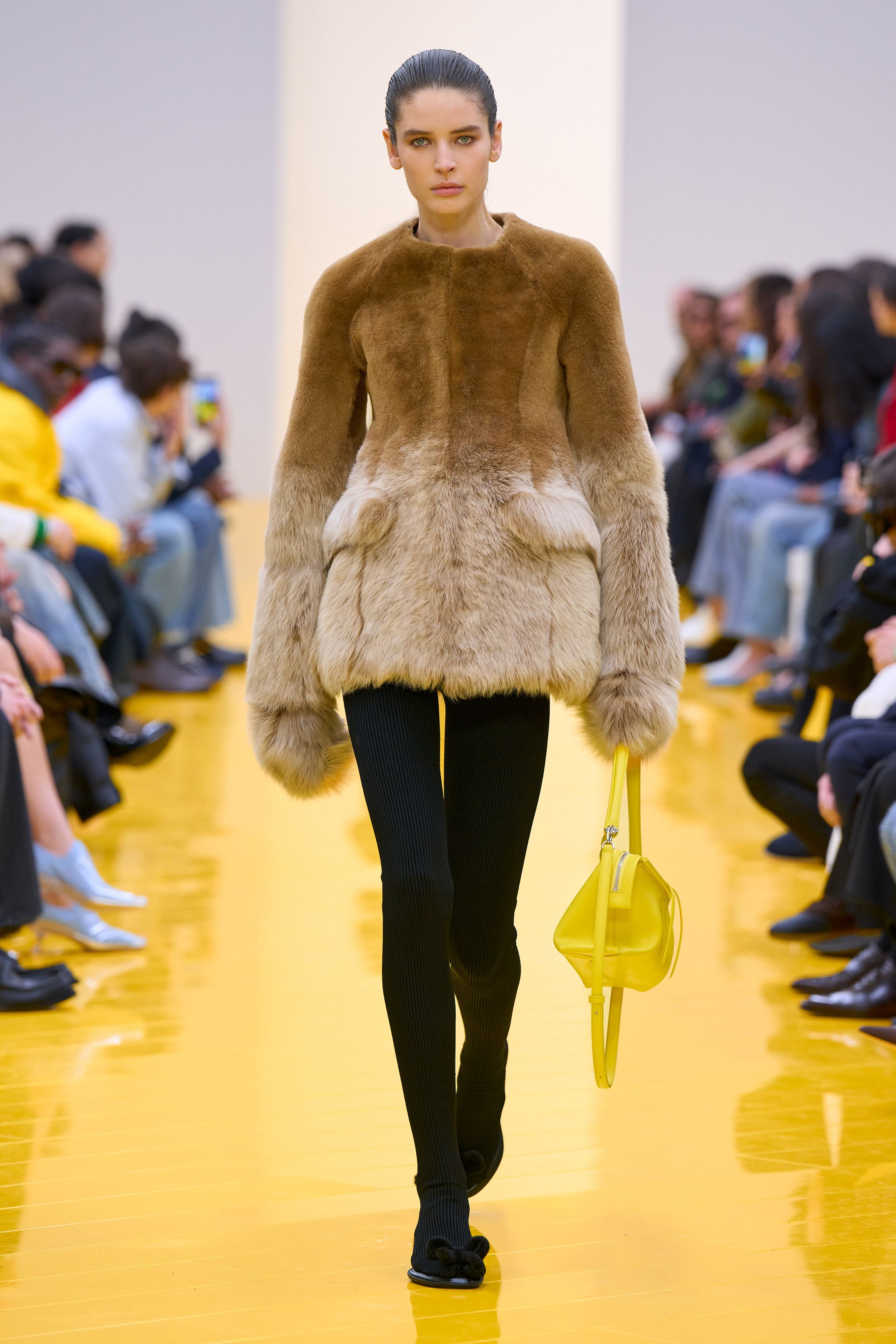 Jonathan Anderson 为 Loewe 带来一场充满艺术实验的秀：黄色地面与鲜明色彩形成强烈视觉舞台，极简廓形针织、雕塑化皮革外套、夸张毛绒结构和实验比例裙装共同构建一种“可穿戴雕塑”。从鲜黄、亮蓝到浓郁棕色毛绒，材质对比成为本季核心语言，既有幽默感也带有博物馆式艺术气质-顽石频道趋势研究